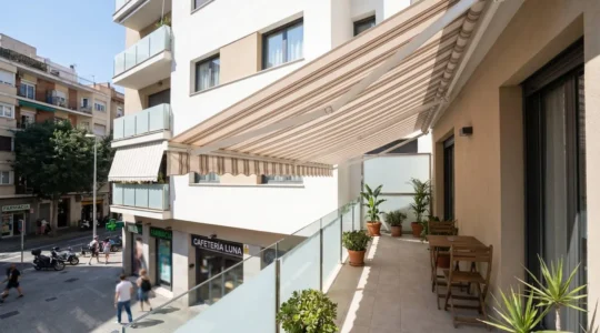 Vista amplia de un balcón urbano contemporáneo con toldo logia desplegado en edificio residencial español