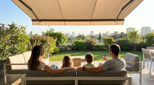 Una familia vista de espaldas disfruta de una terraza contemporánea con un toldo desplegado durante una tarde soleada