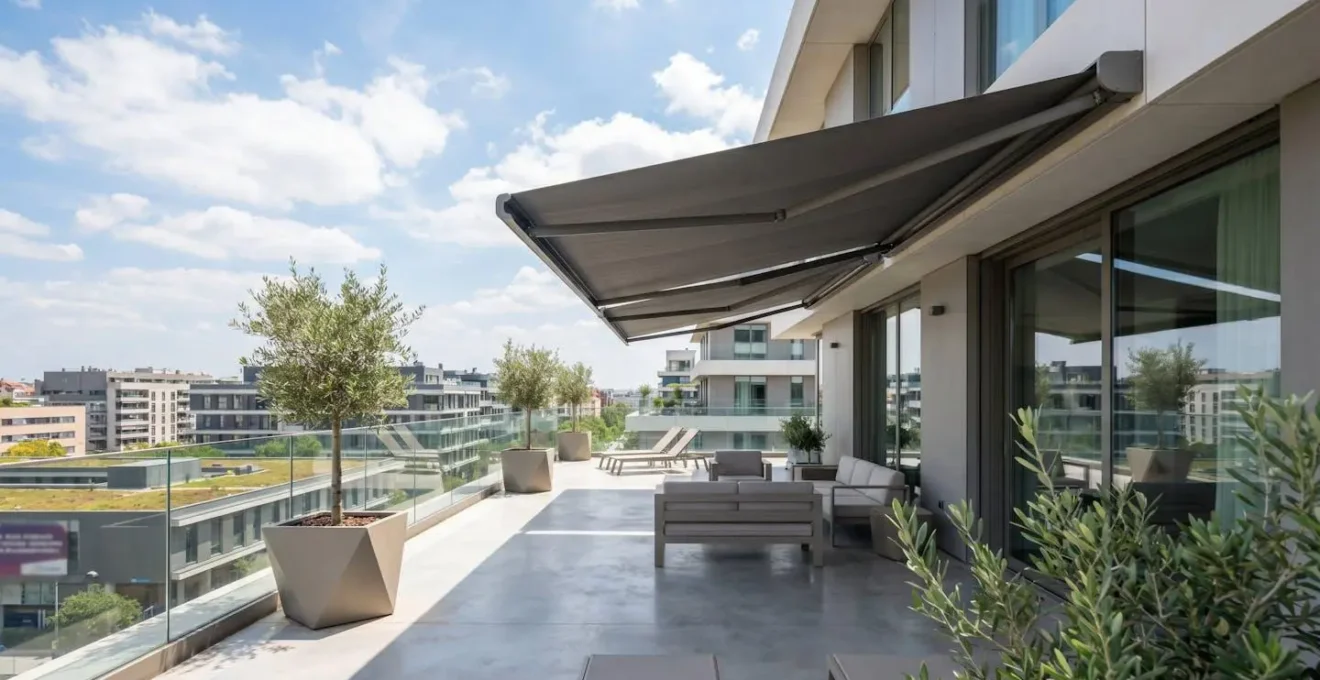 Vista gran angular de una terraza contemporánea con toldo cofre en posición recogida bajo un cielo luminoso